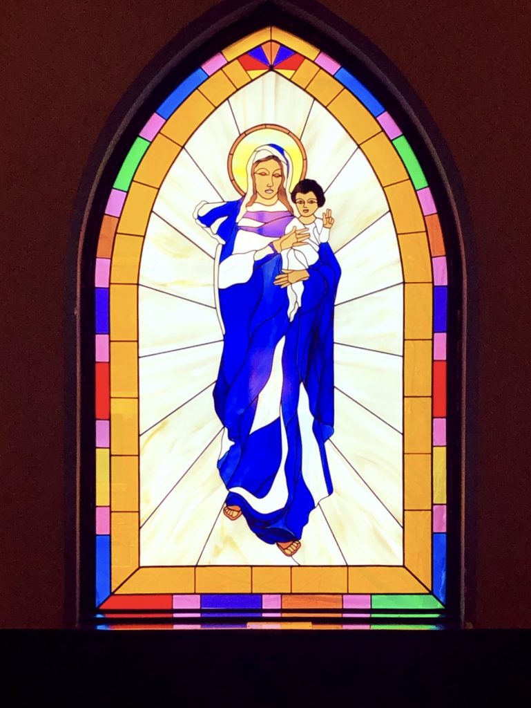 Stained glass window of Mary holding baby Jesus.